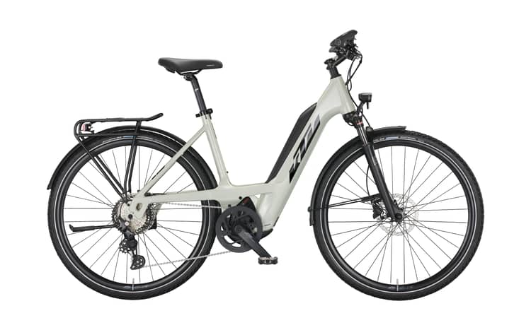 Modern KTM Macina Sport 630 e-bike in silver and black with orange accents, efficient design, and mounted rear rack.