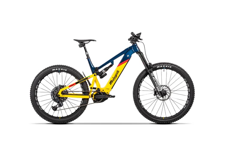 High-performance Malaguti Superiore LTD mountain bike with yellow and blue frame, front suspension, and black Maxxis tires.