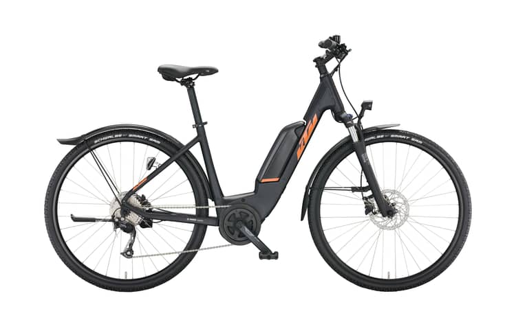 Electric bicycle KTM Macina Cross with orange accents, Bosch motor, disc brakes, and Schwalbe tires on a white background.