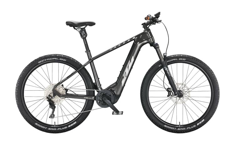 Black KTM Macina Team electric mountain bike with Schwalbe tires and Bosch drivetrain, against a white background.