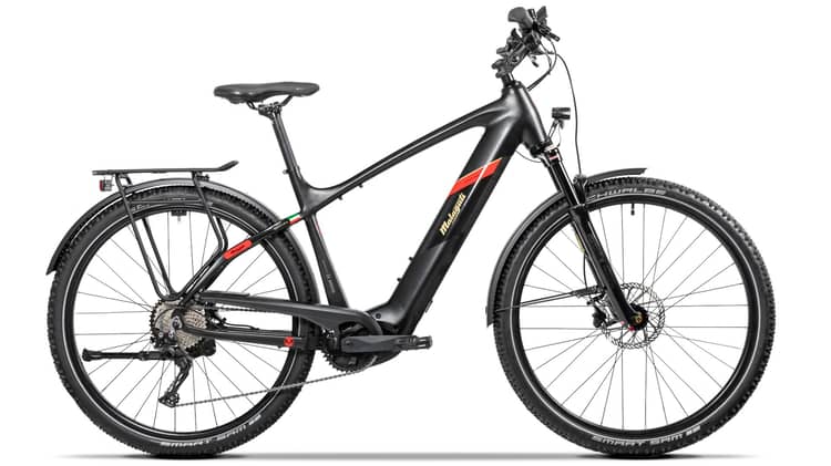 Modern Malaguti Cortina TR-52 electric mountain bike with rear rack, fenders, and knobby tires on white background.